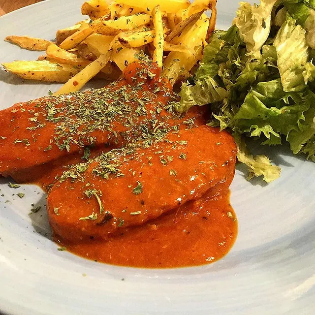 `Seitan mit scharfer Orangensauce, selbstgemachten Pommes und Salat`