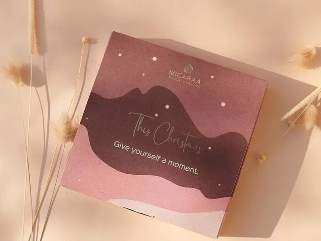 Die Geschenk-Box aus Graspapier liegt auf dem Tisch zwischen Grashalmen.