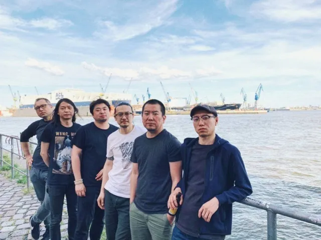 Wang Wen stehen im Hafen an ein Geländer gelehnt.