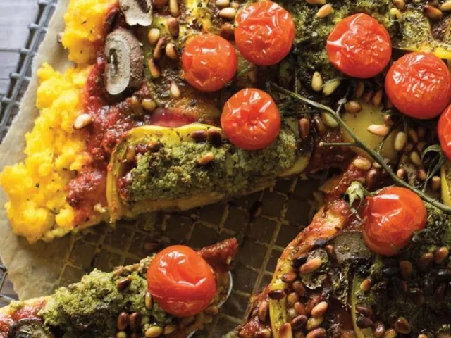 Polenta-Pizza von Lena Marie Radu - Eine angeschnittene Pizza mit Tomaten, Pilzen und grünen Kräutern auf einem dicken, gelblichen Teig auf einem Rost.