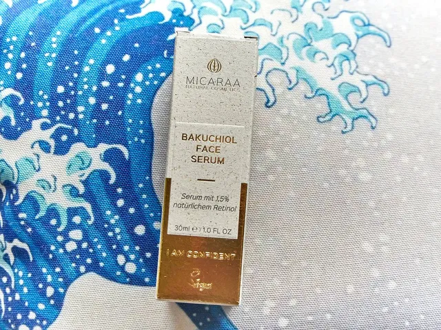 Der beige MICARAA Umverpackungskarton liegt auf einem Kissen mit Wellenmotiv.