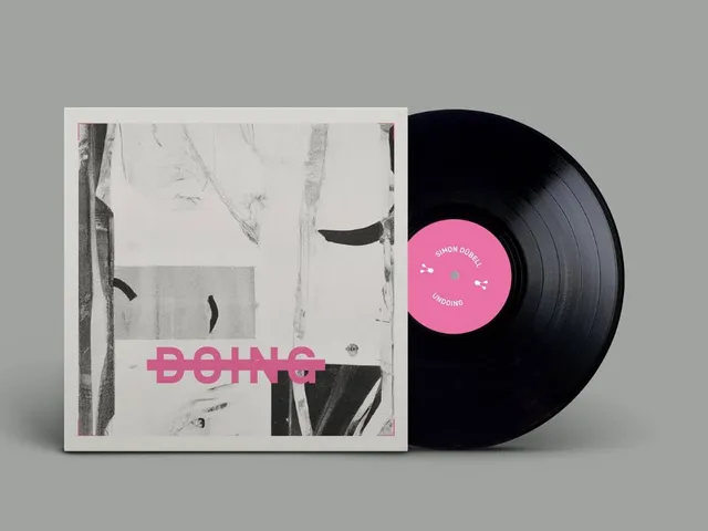 Eine schwarze Schallplatte mit pinkfarbenem Aufkleber steckt zur Hälfte in einer weißen Hülle mit abstraktem Aufdruck mit dem durchgestrichenen Wort "Doing"